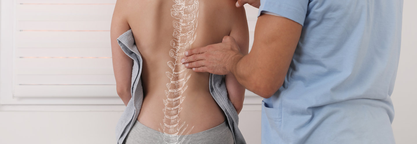 Doctor checking a woman who is experiencing back pain.
