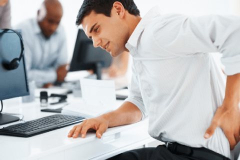 A Man Expressing Back Pain by Placing Hand on His Back